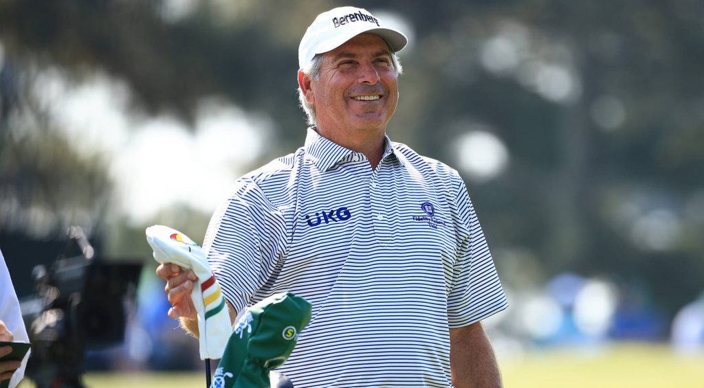 Fred Couples smiling on fairway in striped UKG Berenberg polo holding golf club with headcover Wallpaper