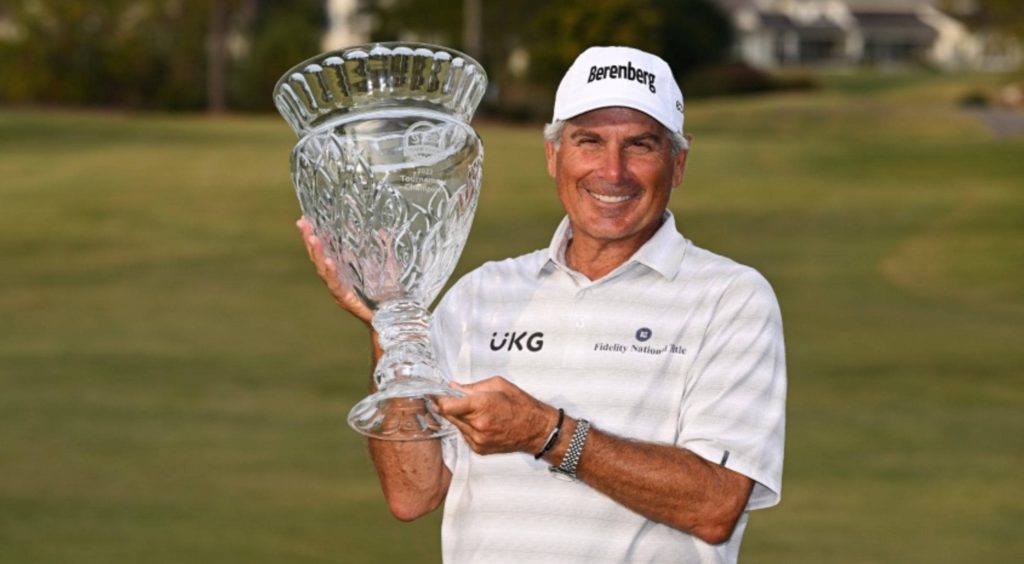 Legendary golfer Fred Couples smiling with crystal trophy on green golf course background Wallpaper