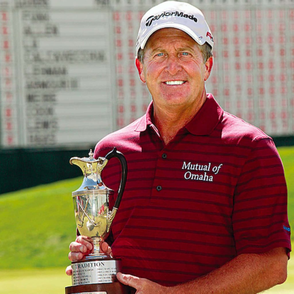 Professional golfer Fred Funk smiles holding The Tradition silver trophy on sunny golf course Wallpaper