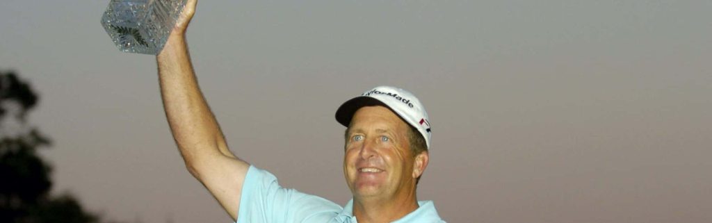 Professional golfer Fred Funk celebrating tournament win holding crystal trophy in blue polo Wallpaper