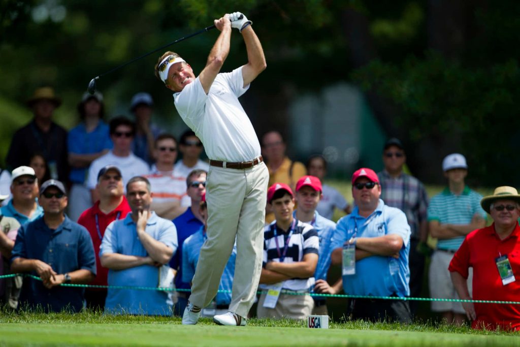 Fred Funk mid swing on vibrant golf course with spectators and USGA marker background wallpaper