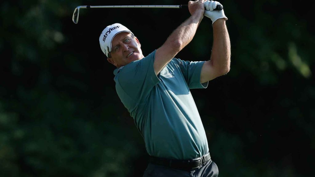Fred Funk golf swing wallpaper with white Stryker hat teal shirt dark dramatic background