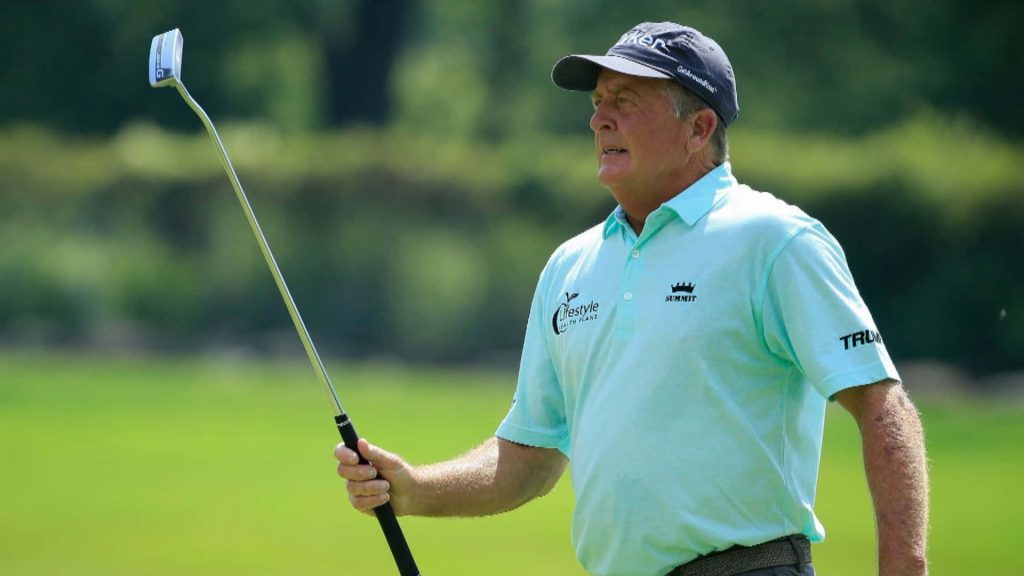 Fred Funk in light blue polo holding putter on green fairway golf wallpaper background
