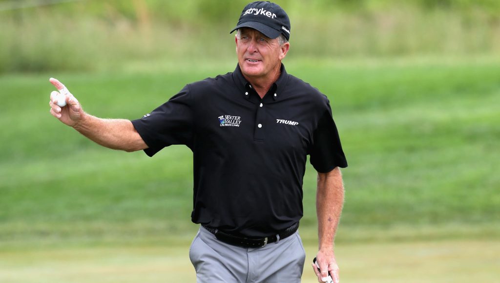 Fred Funk professional golfer holding golf ball in black polo and Stryker cap on golf course Wallpaper