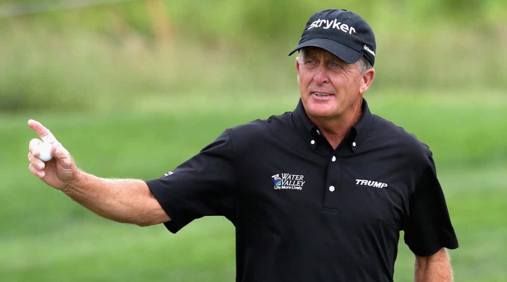 Professional golfer Fred Funk in Trump shirt holding golf ball on green blurred golf course background Wallpaper
