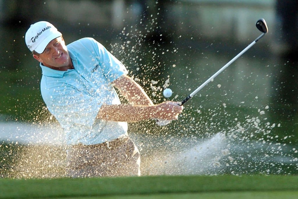 Professional golfer Fred Funk in TaylorMade cap hits powerful bunker shot with sand spray Wallpaper