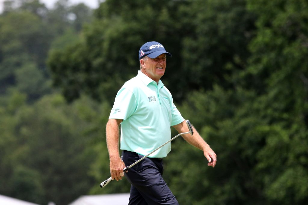 Professional golfer Fred Funk walking green golf course smiling in light green polo navy cap Wallpaper