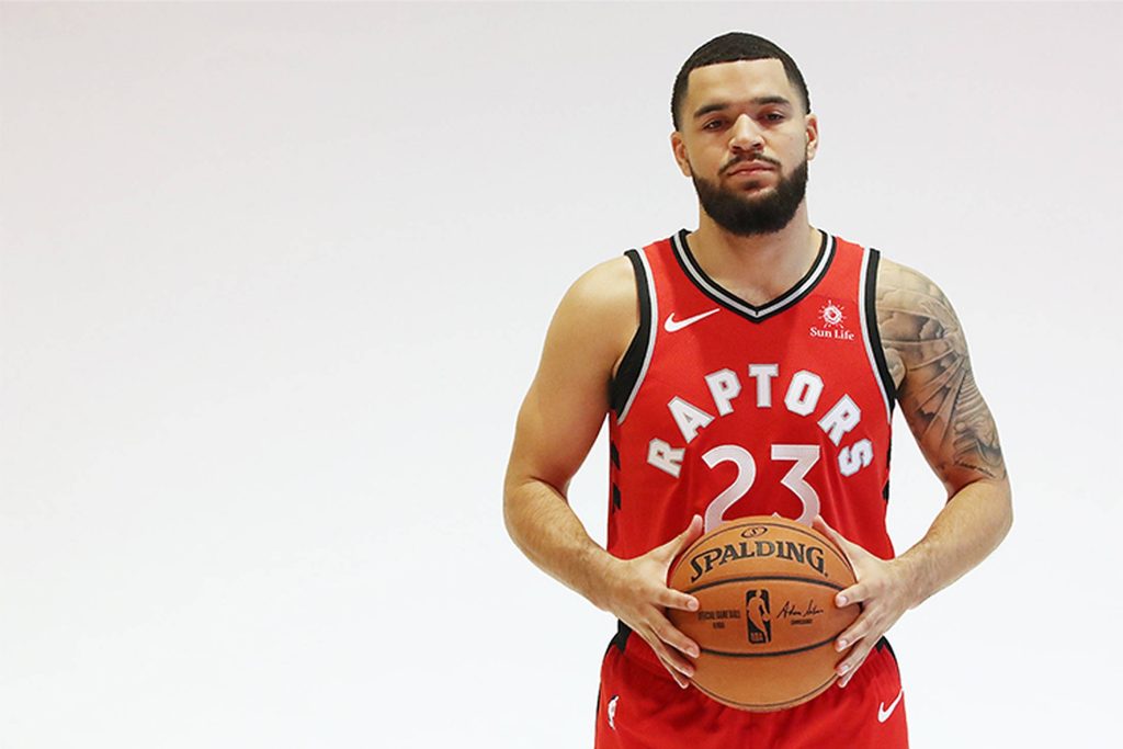 NBA star Fred VanVleet in red Raptors jersey holding basketball bright white background wallpaper