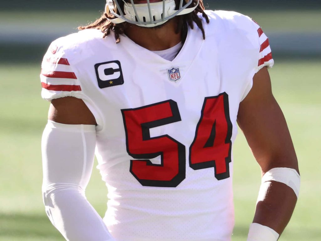 Fred Warner 49ers wallpaper in white jersey number 54 with captain patch NFL action shot background