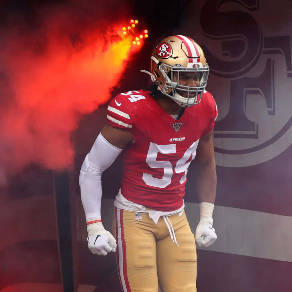 Dynamic Fred Warner Football Wallpaper: 49ers in Red Smoke