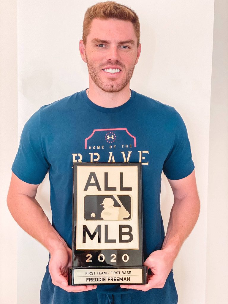 Portrait of MLB star Freddie Freeman smiling with 2020 All-MLB First Base award in blue Braves shirt Wallpaper