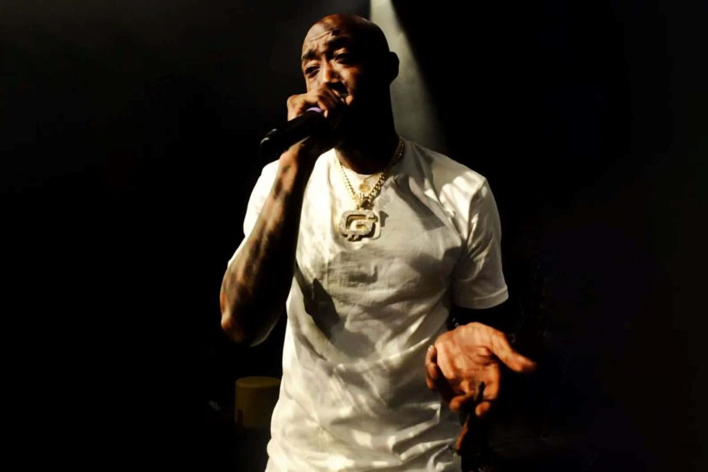 Freddie Gibbs live performance wallpaper high contrast stage lighting white tee gold chain