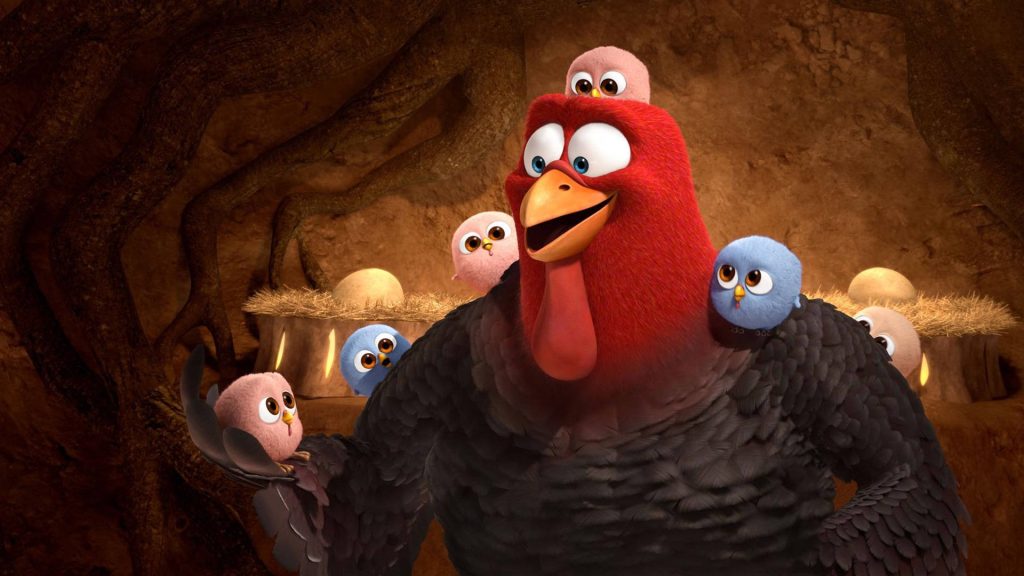 3D Free Birds wallpaper of muscular turkey Jake holding fluffy pink and blue chicks in cozy cave