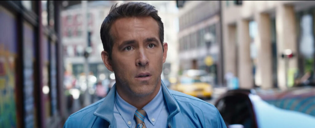 Free Guy Wallpaper: Main Character in Urban Setting with Worried Expression