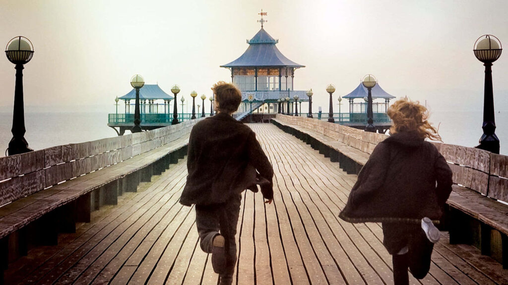 Free Spirits Embracing Life's Journey: Pier-side Escape Wallpaper