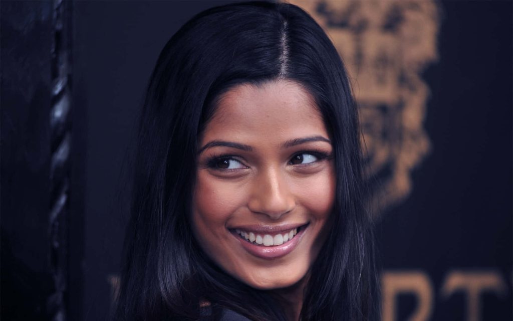 Freida Pinto elegant portrait with radiant smile dark blurred event background high-quality wallpaper