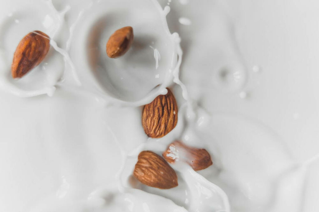 Close-Up of Almond Milk Splash with Whole Almonds - Fresh Wallpaper