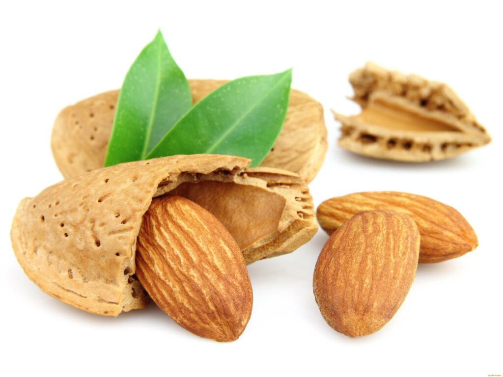 Raw Almonds & Shells with Green Leaves - Natural Wallpaper Background