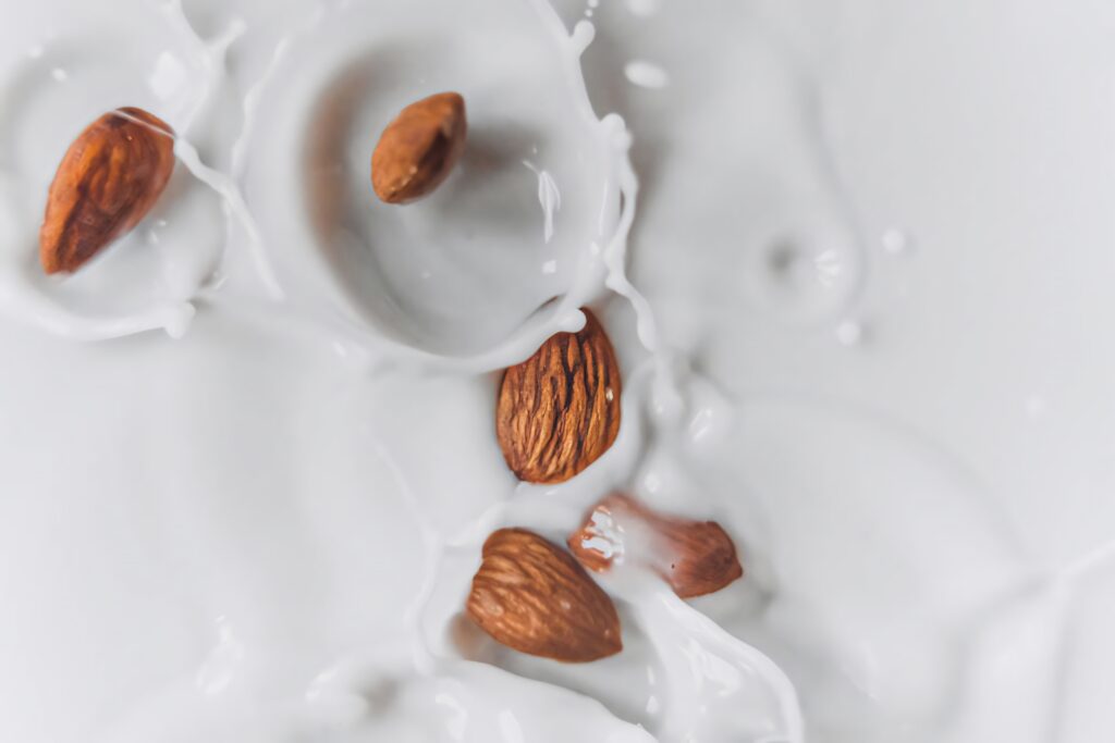 Whole almonds splashing into creamy almond milk fresh dynamic high angle food background wallpaper