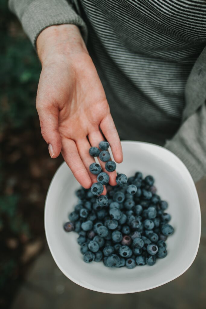 Fresh Blueberries in Hand: Healthy Lifestyle Wallpaper Background