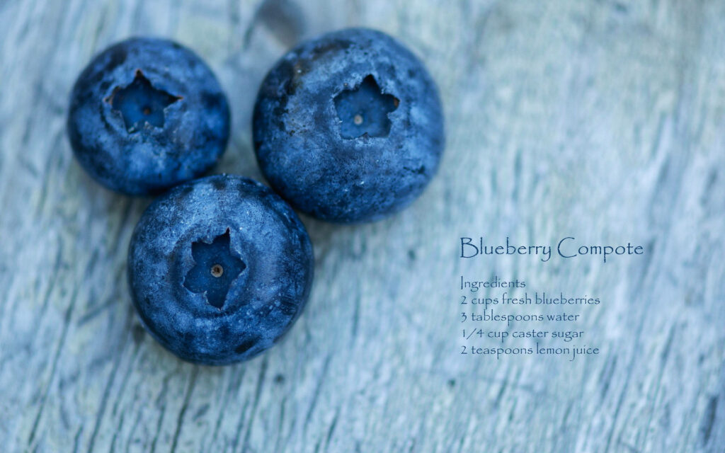 Close-up of fresh blueberries on rustic surface with Blueberry Compote recipe wallpaper background