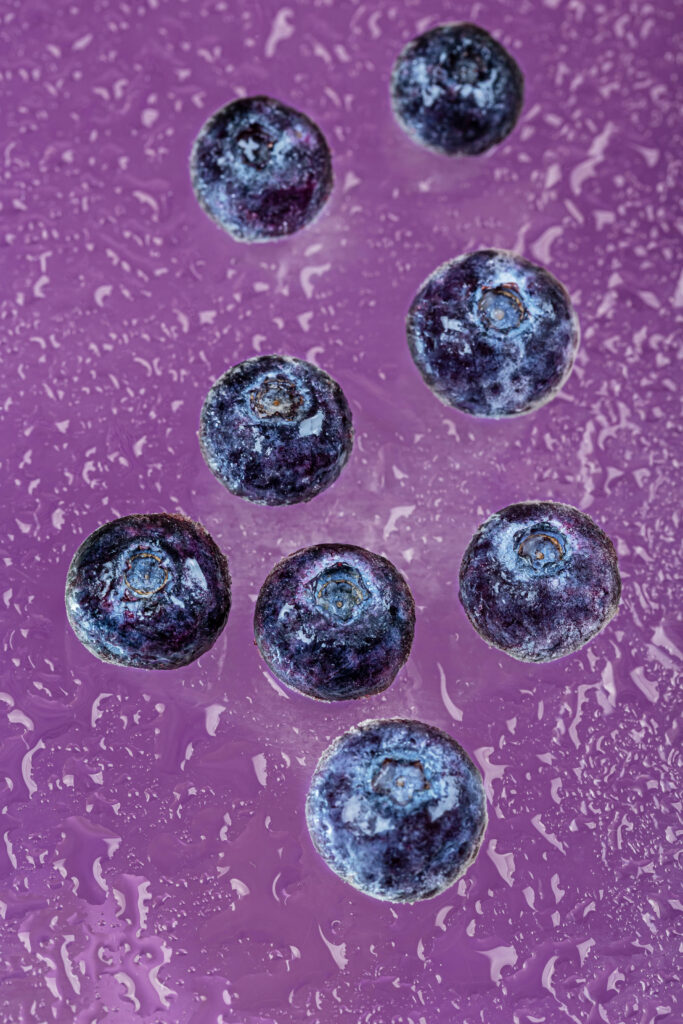 Macro Close-Up of Juicy Blueberries on Vibrant Purple Wallpaper