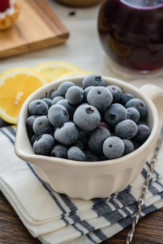 Frozen Blueberries in White Bowl with Lemon on Checkered Cloth Wallpaper