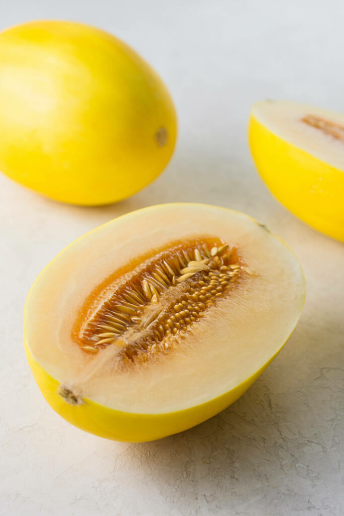 Fresh canary melon with bright yellow rind and juicy interior showcasing seeds and texture Wallpaper