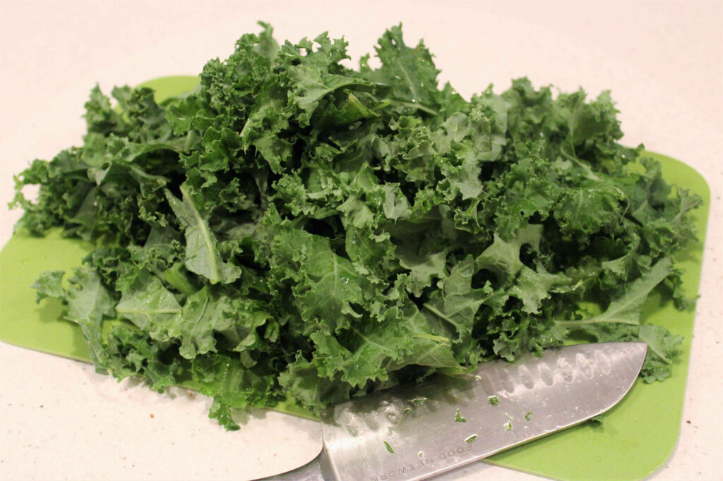 Fresh Kale Leaves Wallpaper: Textured Green Cabbage on Cutting Board
