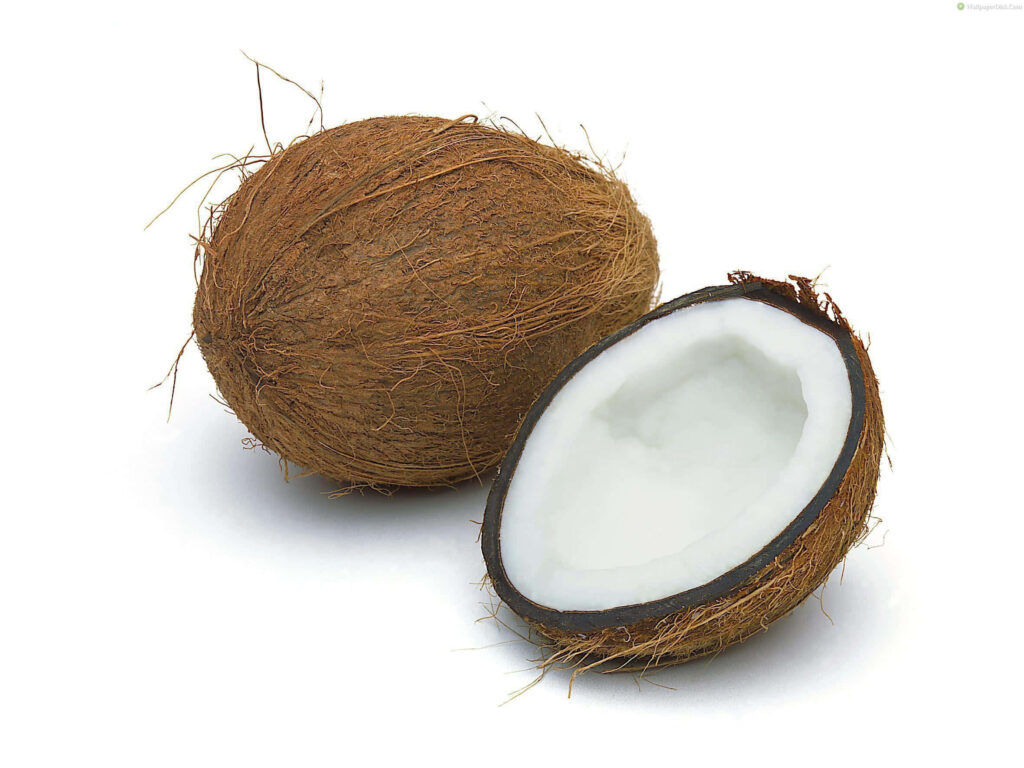 Fresh coconut split open showing white juicy interior and rough shell on white background Wallpaper