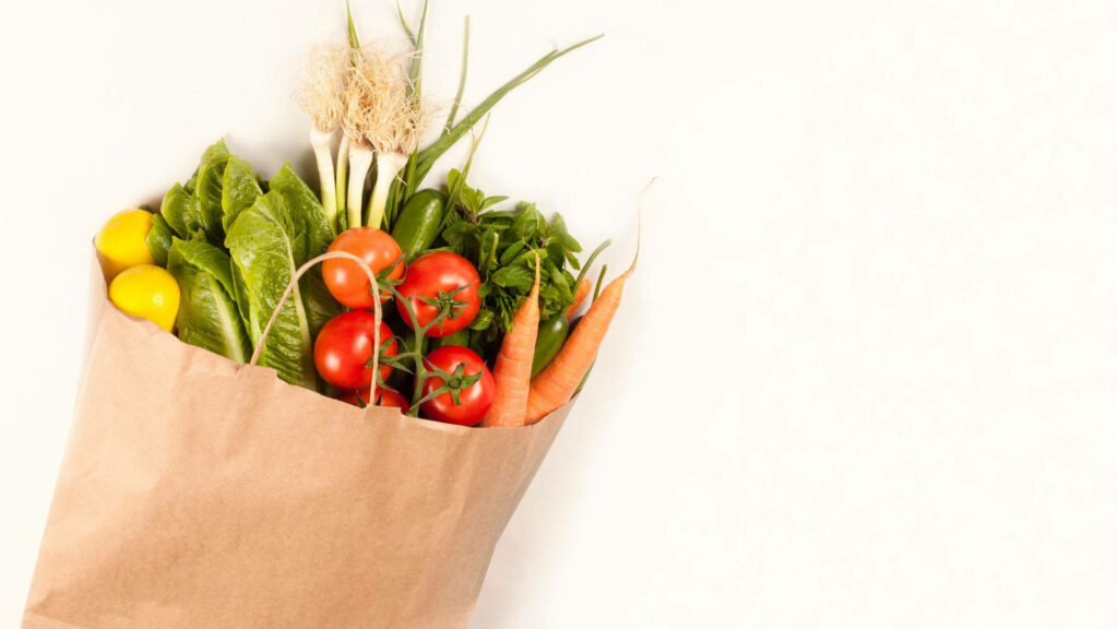 Fresh Grocery Wallpaper: Colorful Paper Bag with Vibrant Produce
