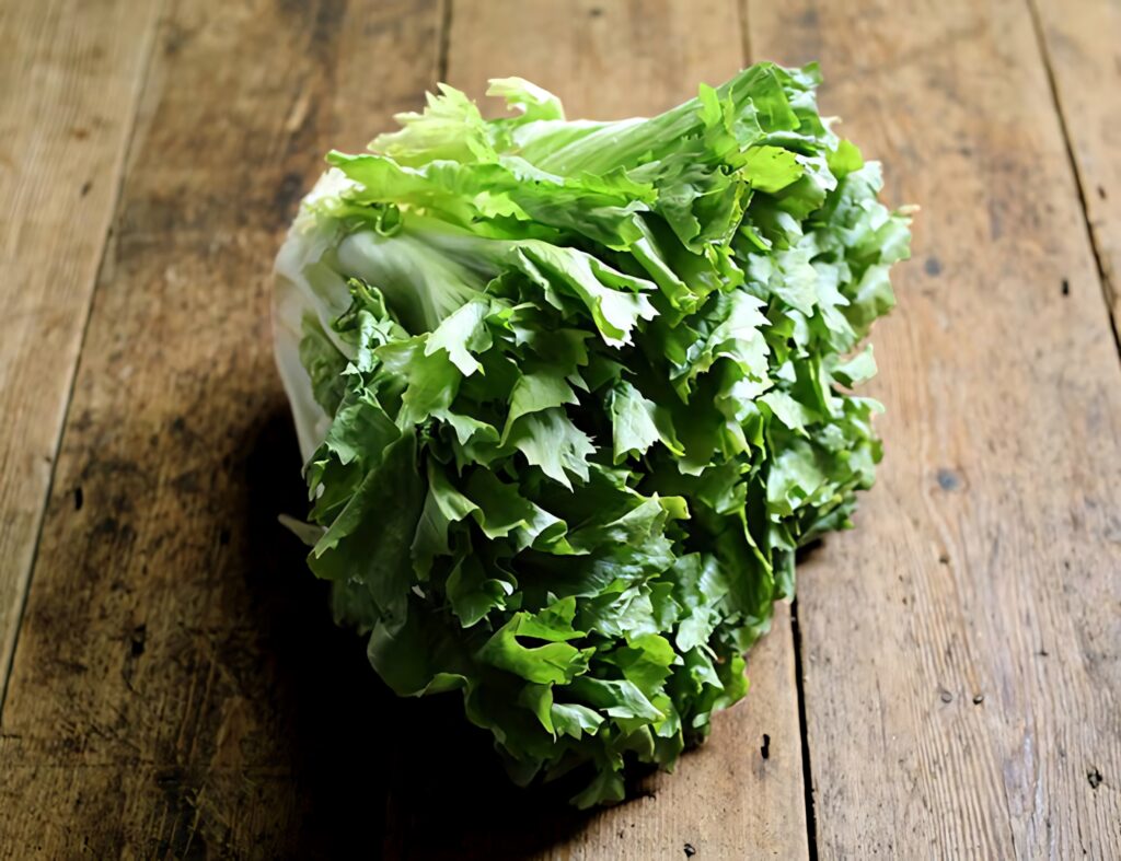 Vibrant Escarole Lettuce Wallpaper on Rustic Wooden Table
