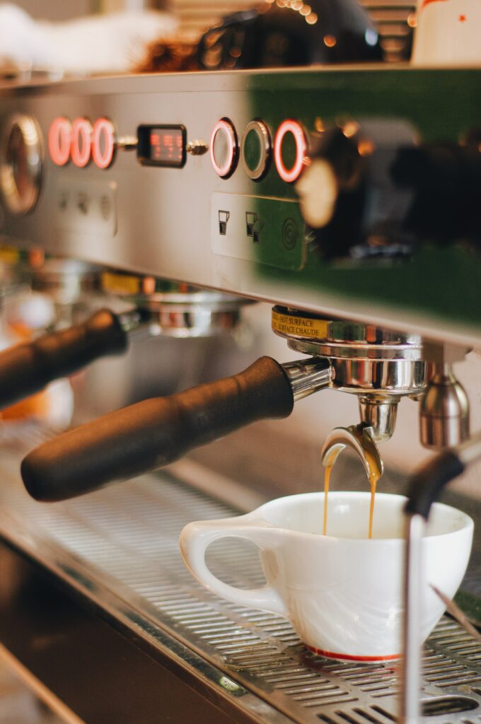 Fresh Espresso Pouring: Coffee Machine Close-Up in Cozy Café Wallpaper