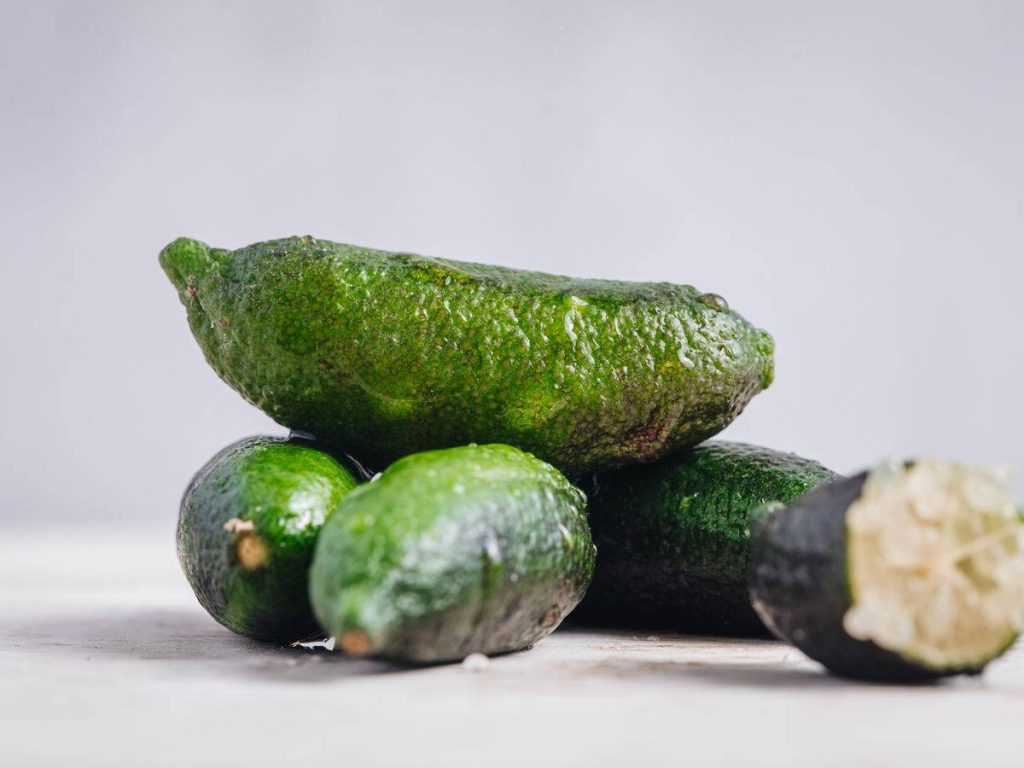 Macro photo of fresh finger limes showing textured skin and citrus caviar vesicles background Wallpaper