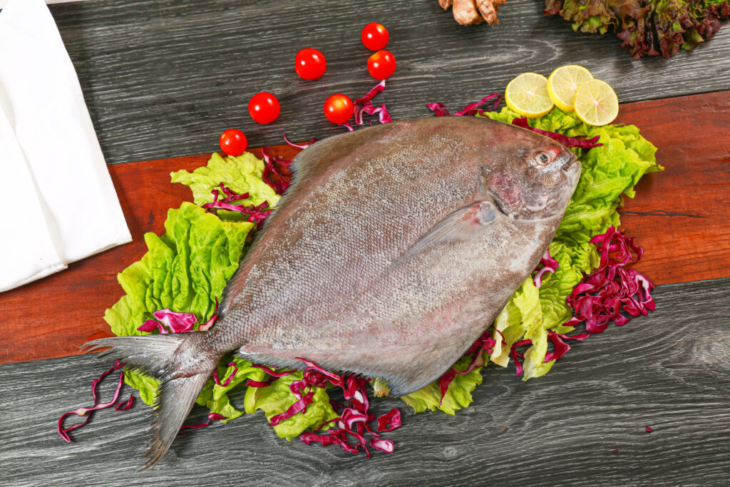 Fresh Flounder Flat Lay with Lettuce, Tomatoes, and Lemon on Wood Wallpaper