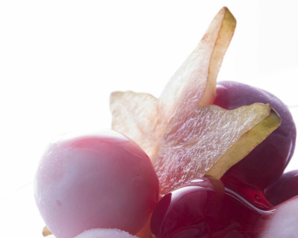 Vibrant Fruit Wallpaper: Glossy Grapes & Starfruit on White Background