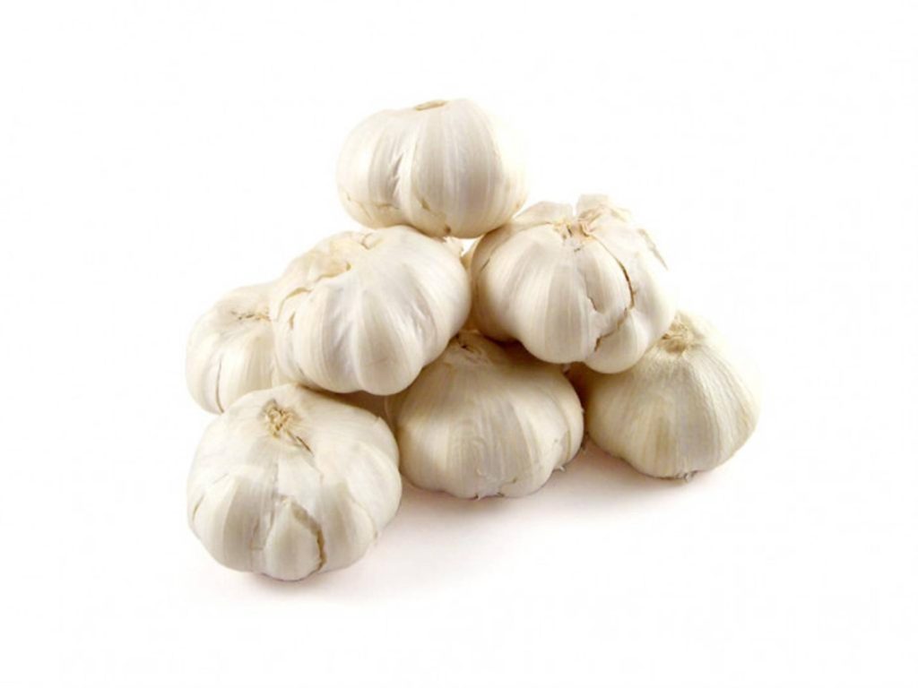 Pyramid stack of fresh whole garlic bulbs on white background with natural texture details Wallpaper