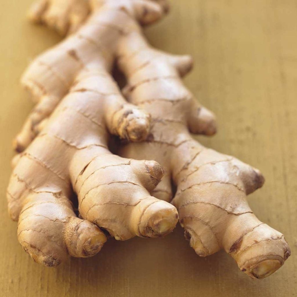 Macro photo of fresh ginger root on wooden surface with natural texture and warm lighting Wallpaper