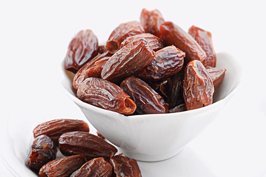White ceramic bowl of glossy fresh dates with rich brown tones on bright clean background wallpaper