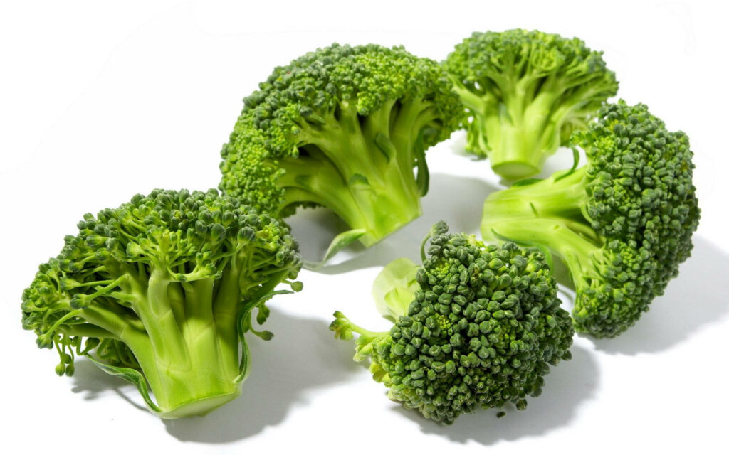 Five vibrant green broccoli heads on white background fresh healthy vegetables wallpaper