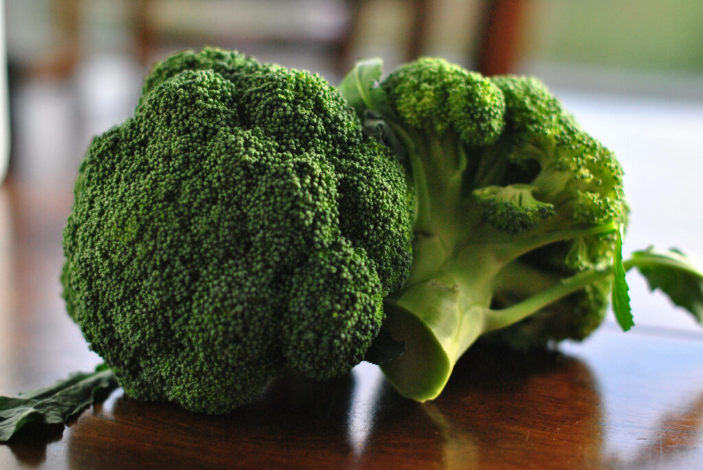 Fresh green broccoli florets on brown wooden table healthy organic vegetables wallpaper background