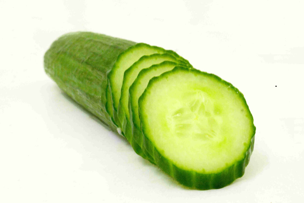 Fresh green cucumber slices arranged on white background crisp texture minimal wallpaper