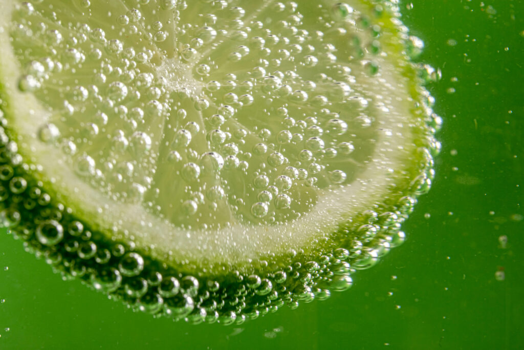 Vibrant Lime Slice in Water: Macro Wallpaper Background