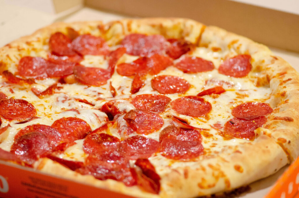 Fresh pepperoni pizza with melted cheese in open box ready to eat tasty Italian meal wallpaper