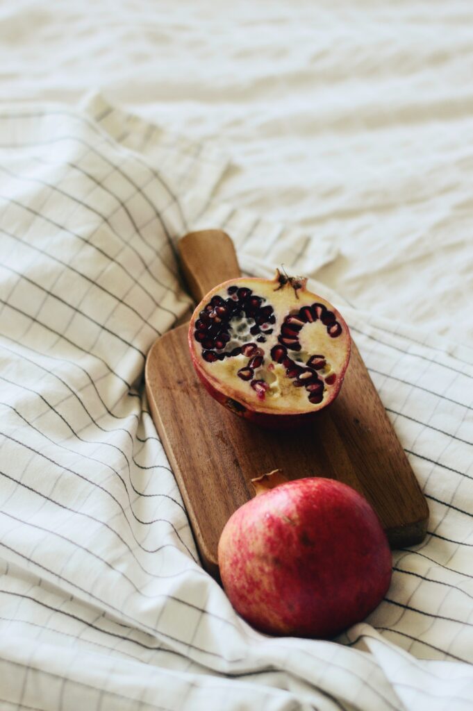 Fresh Pomegranate Wallpaper on Wooden Board with Checkered Cloth