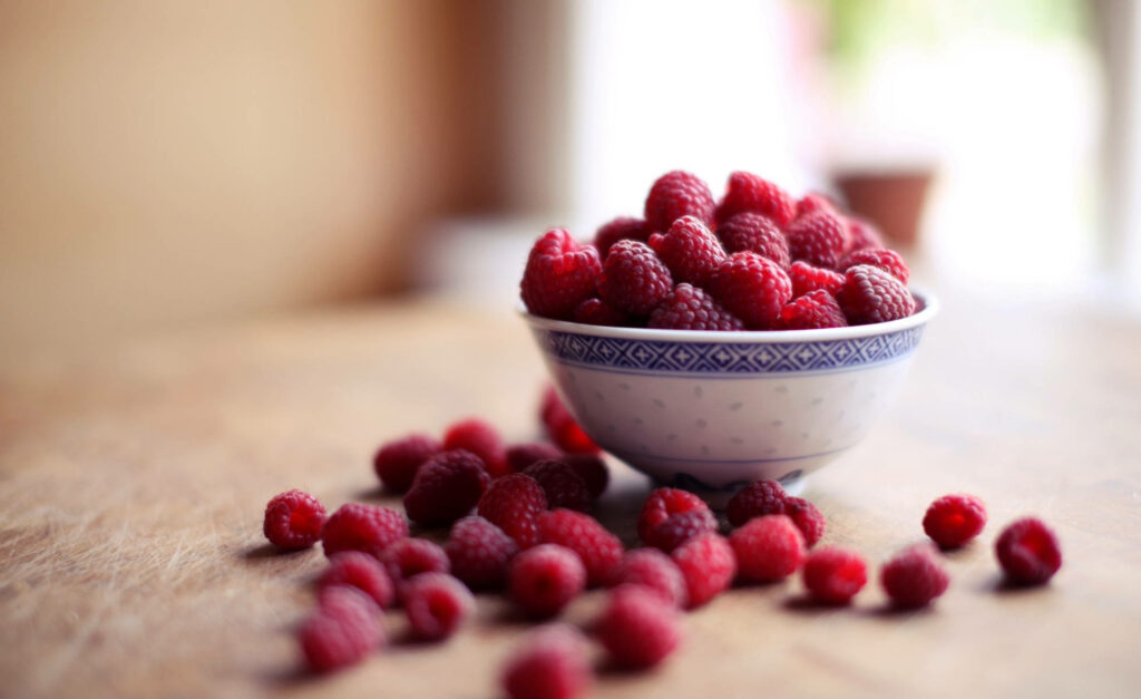 Vibrant Raspberry Wallpaper: Fresh Bowl on Rustic Wood Background