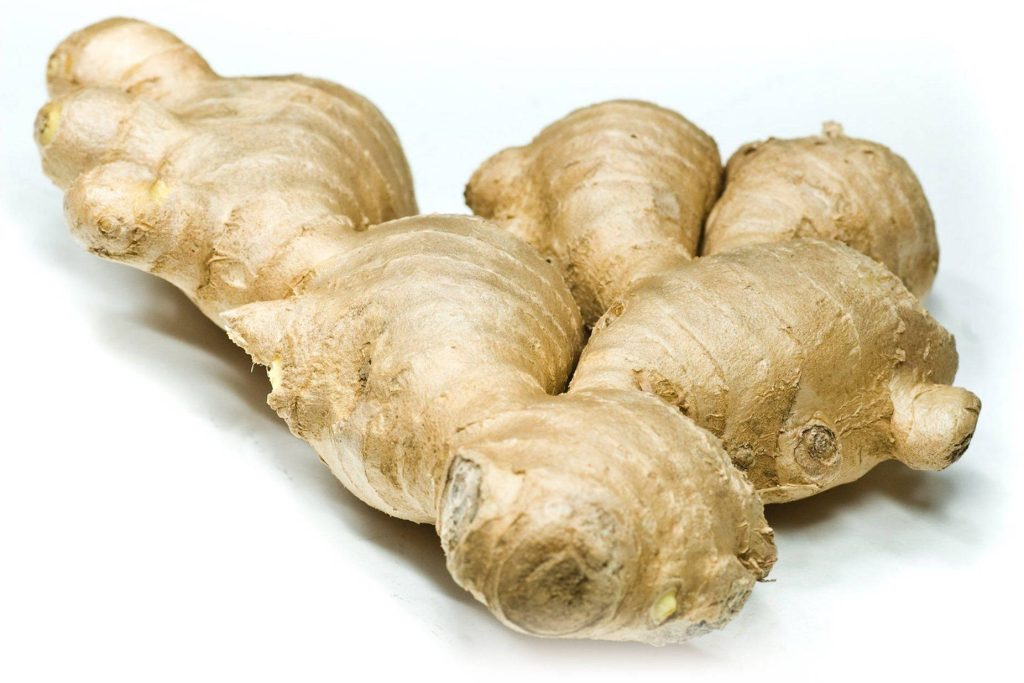 Close-up of fresh raw ginger root with knobby texture on white background for cooking use Wallpaper