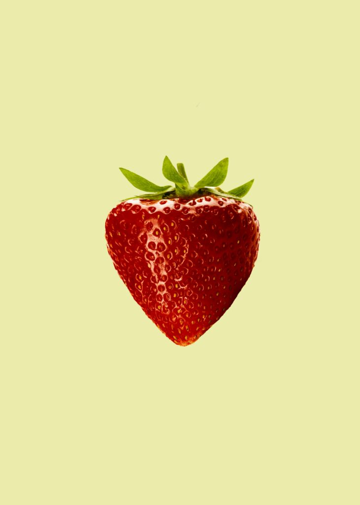 Vibrant Red Strawberry Close-Up on Beige Wallpaper Background