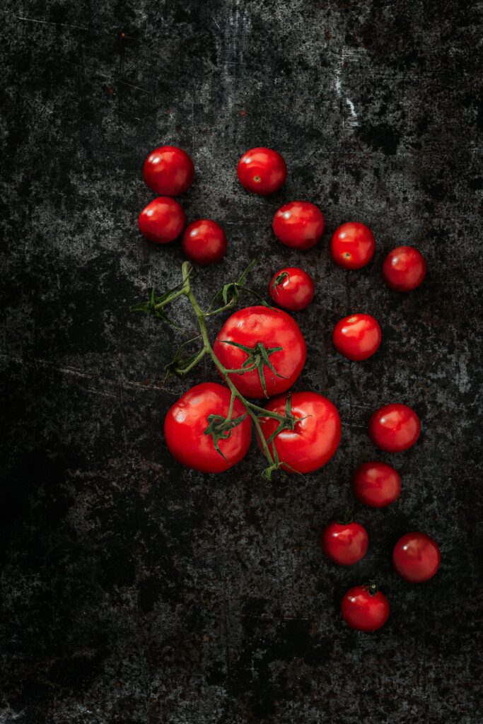 Fresh Red Tomatoes Wallpaper on Dark Textured Surface - Organic Aesthetic