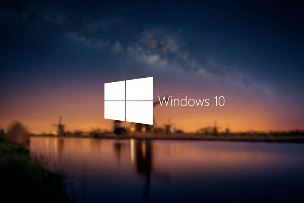 Windows 10 wallpaper with white logo over serene blurred Dutch windmills at sunset landscape